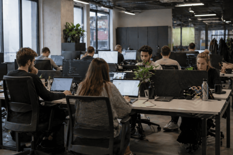 Zespół pracuje przy komputerach w otwartym biurze typu open space